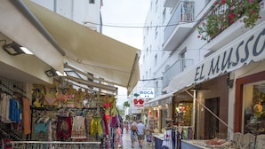 A narrow street with shops on either side, including a visible sign for 'El Musso' and 'Hostal Rocha'. - Hostal Roca (Sant Antoni de Portmany)
