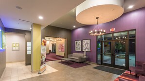 A lobby with a reception desk, seating area, and a large chandelier. - Holiday Inn San Marcos-Convention CTR Area by IHG (San Marcos)