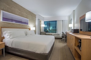 A hotel room with a large bed, a desk, a chair, a television, and a window with curtains. - Holiday Inn San Marcos-Convention CTR Area by IHG (San Marcos)