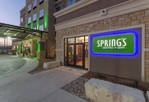 A building with a sign for 'SPRING'S BISTRO + BAR' and a covered entrance area. - Holiday Inn San Marcos-Convention CTR Area by IHG (San Marcos)