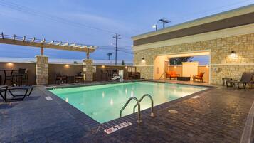 Una piscina al aire libre, tumbonas