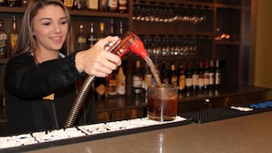 A bartender pouring a drink into a glass. - Holiday Inn San Marcos-Convention CTR Area by IHG (San Marcos)
