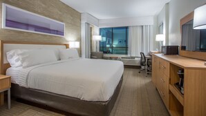 A hotel room with a large bed, a desk with a computer, a chair, and a window with curtains. - Holiday Inn San Marcos-Convention CTR Area by IHG (San Marcos)