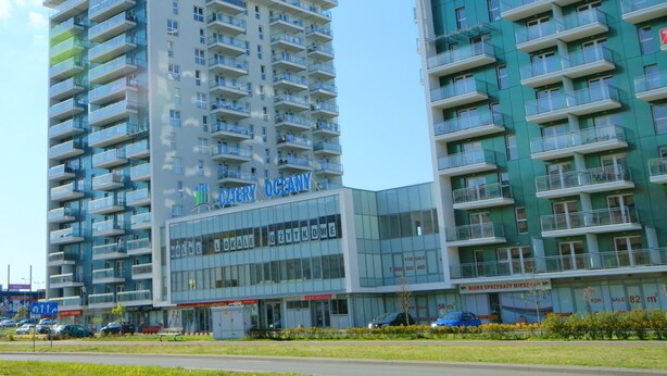 A modern high-rise building with multiple balconies and a glass facade. - IRS ROYAL APARTMENTS - IRS Cztery Oceany (Gdansk)