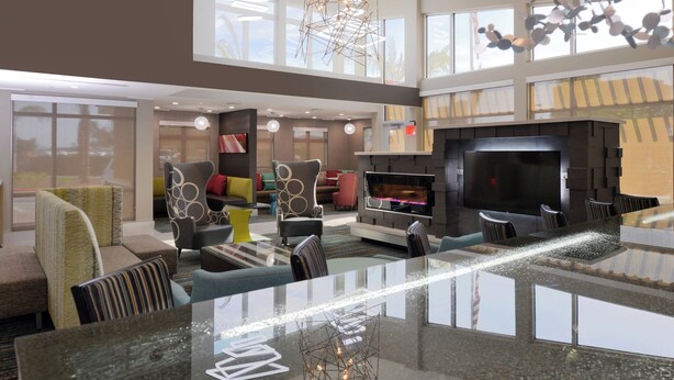 Un hall d’entrée spacieux avec un grand espace salon, une cheminée et un lustre moderne.