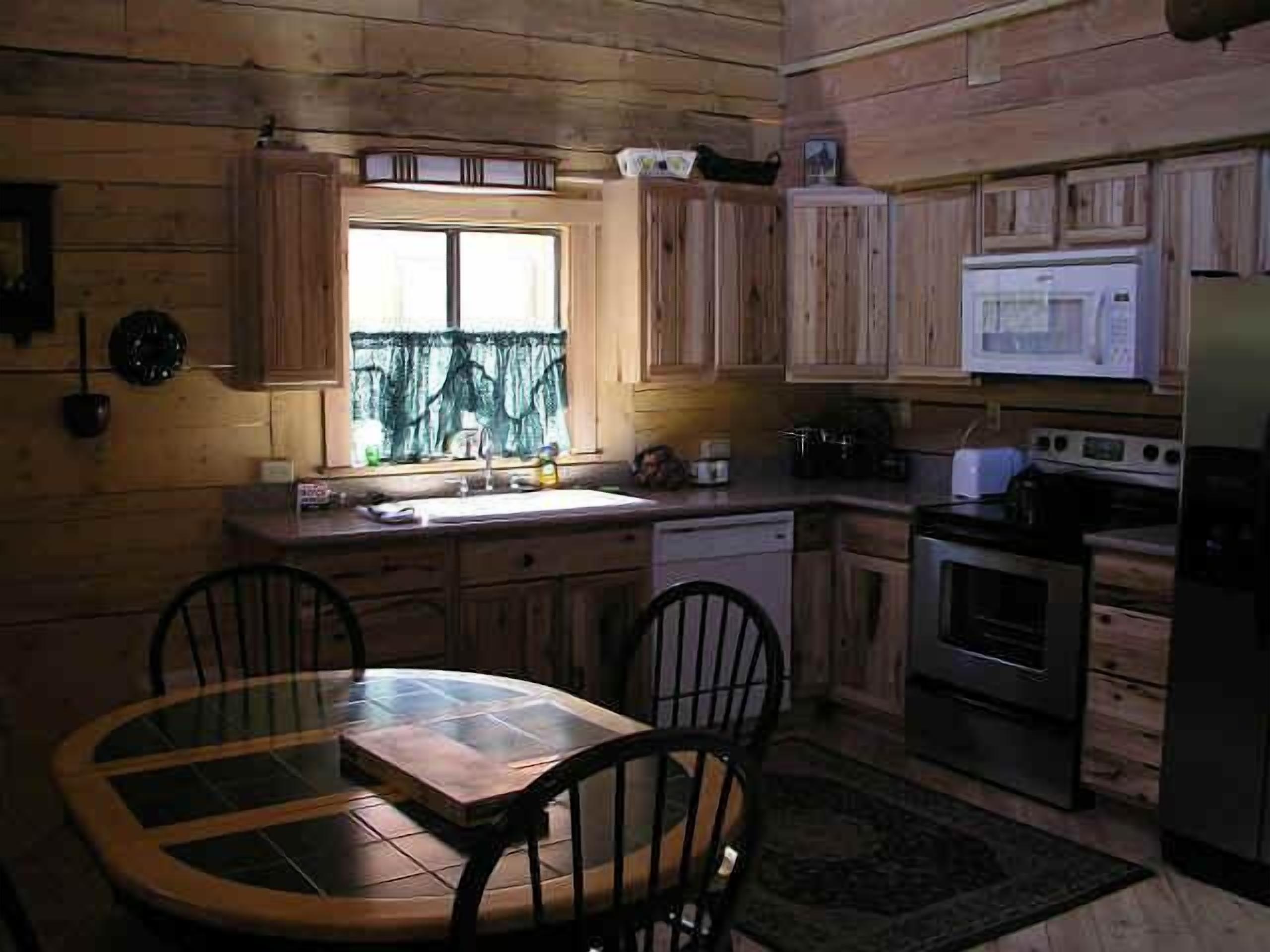 Una cocina compacta con armarios de madera, un microondas y una estufa.