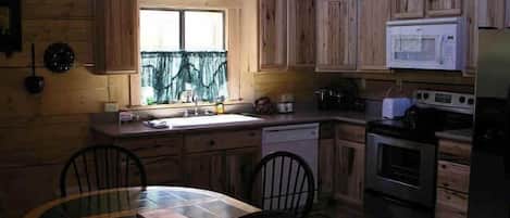 Una cocina compacta con armarios de madera, un microondas y una estufa.