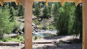 A wooden structure with a view of a river and forest. - Texan Resort (Lake City)