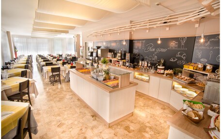 A restaurant with a central bar area, multiple seating tables, and a chalkboard menu.