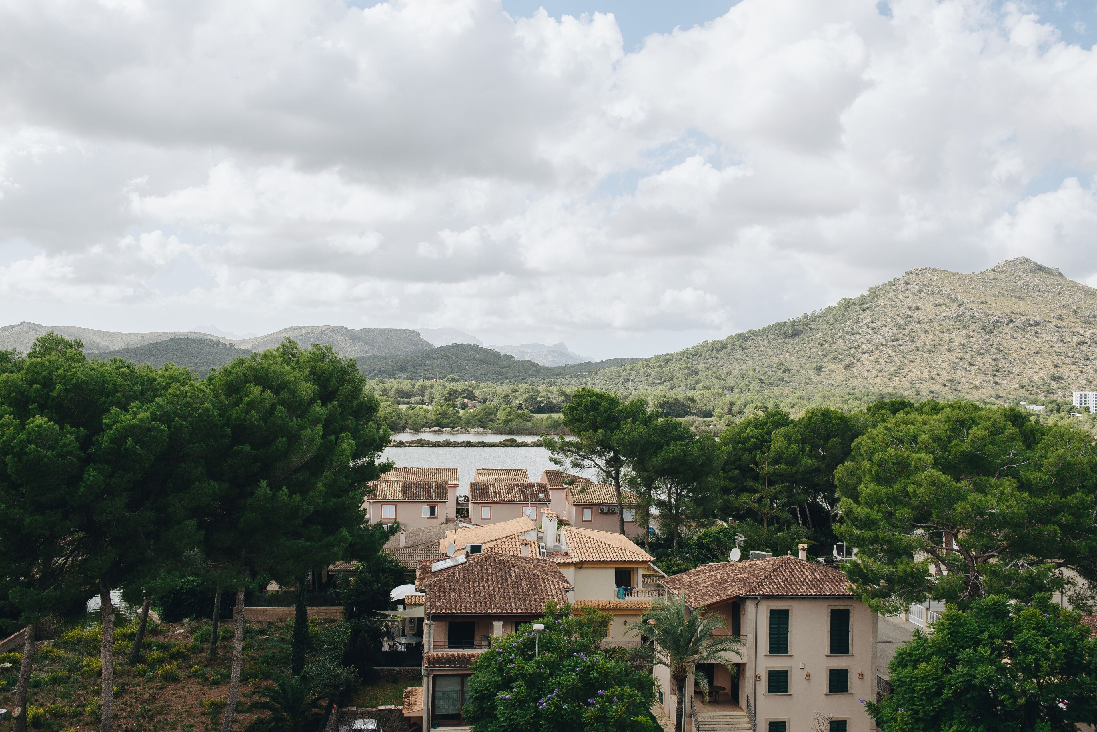 Un quartier résidentiel où les maisons se distinguent par leurs toits en tuiles de terre cuite, avec une chaîne de montagnes en arrière-plan.