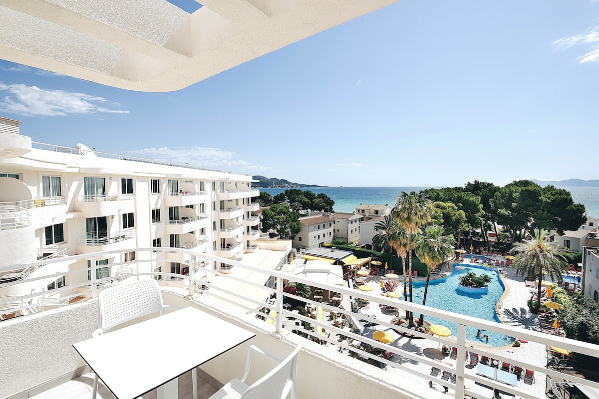 Un hôtel doté d’une piscine, d’un espace extérieur aménagé et offrant une vue sur la mer.