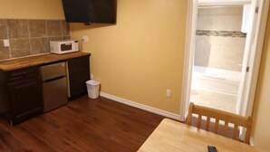 A compact kitchen with a microwave, a small dishwasher, and a trash bin. - Twin Peaks Motel (Greater Napanee)