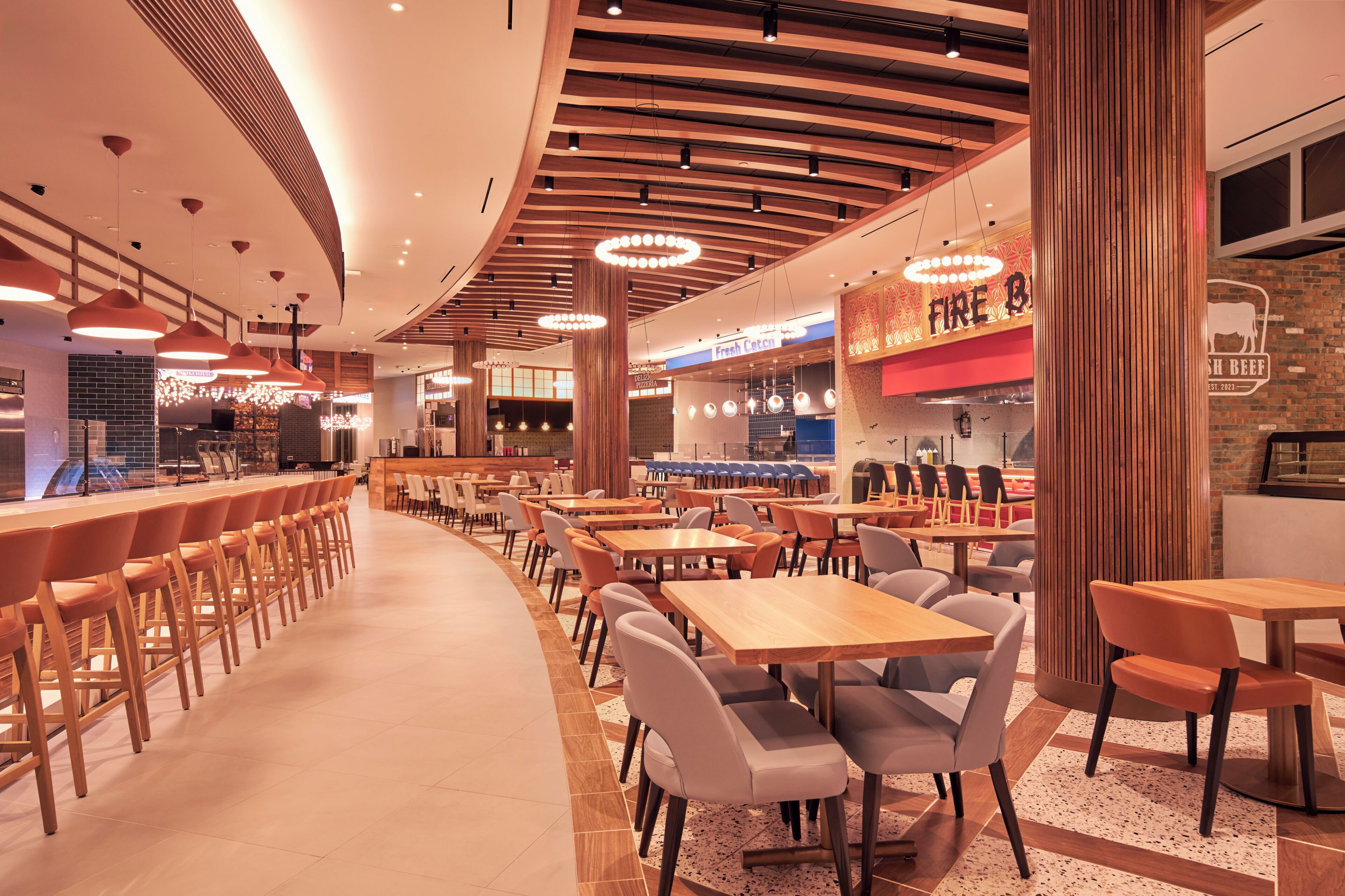 A modern restaurant with a bar area, multiple seating options, and a visible menu board.