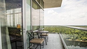A balcony with a glass railing, a table, and two chairs. - Wind Creek Casino & Hotel Wetumpka (Wetumpka)
