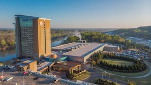 A hotel with a prominent tower, a parking area, and a landscaped golf course. - Wind Creek Casino & Hotel Wetumpka (Wetumpka)