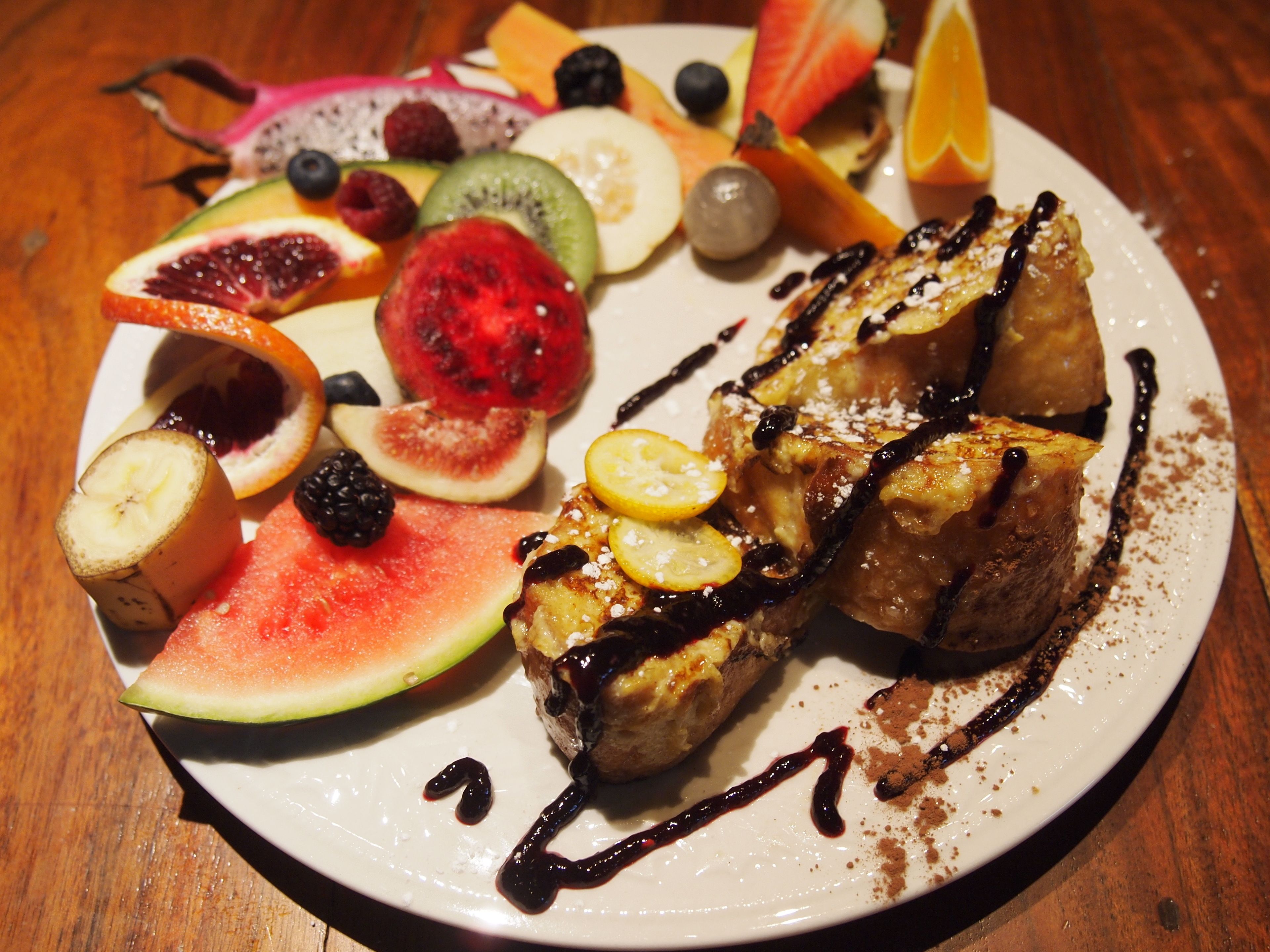 Un plato de comida con diversas frutas y un postre.
