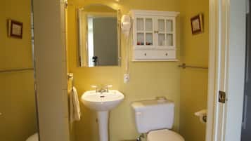 A bathroom with a white sink, toilet, and vanity cabinet.