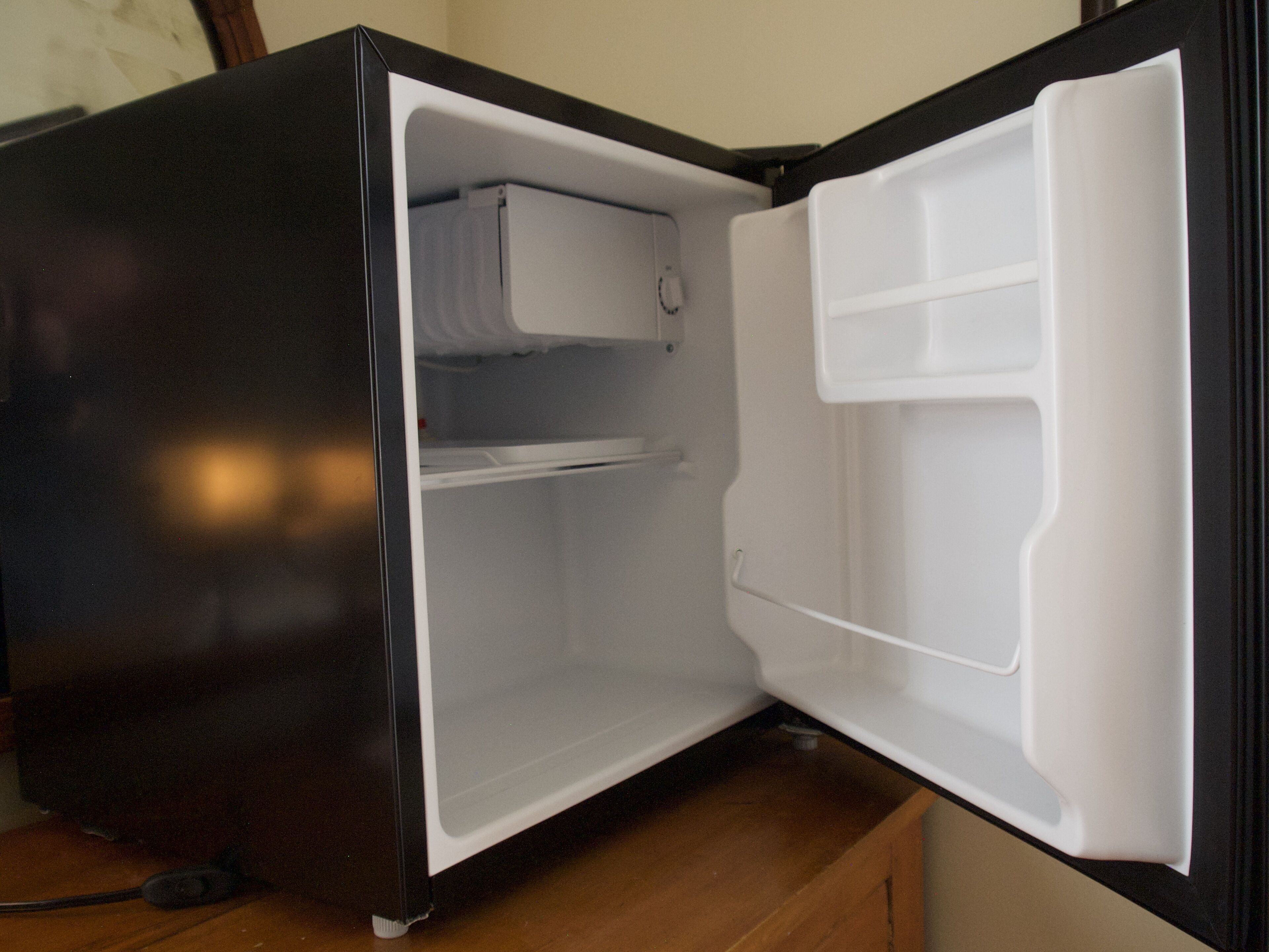An open refrigerator with a freezer compartment on the left and a main compartment on the right.
