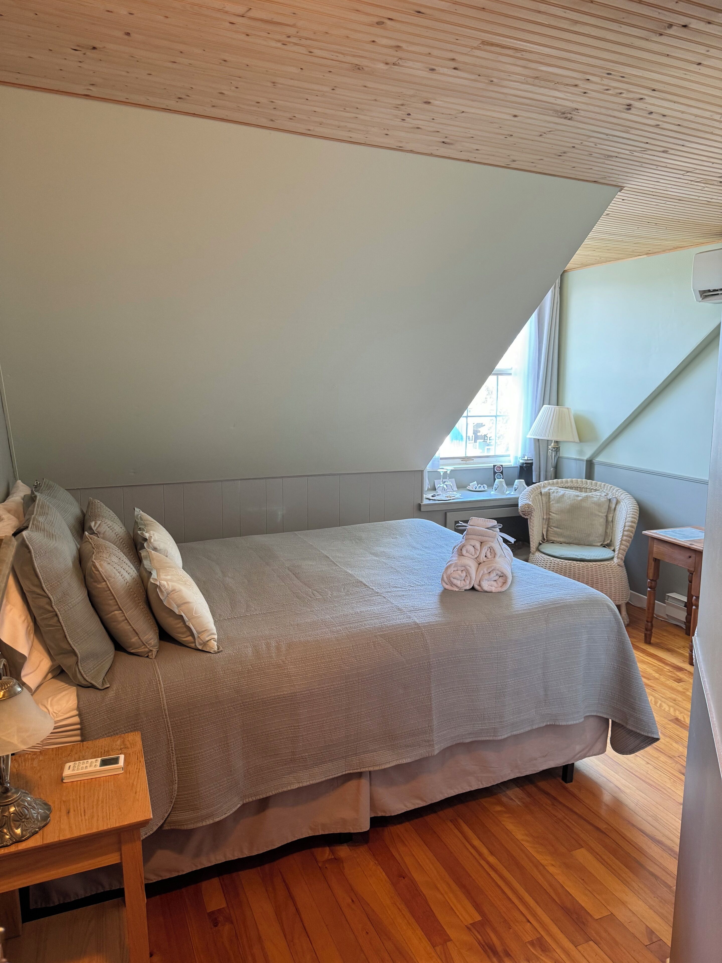 Un dormitorio con una cama grande, un escritorio, una silla y una ventana.