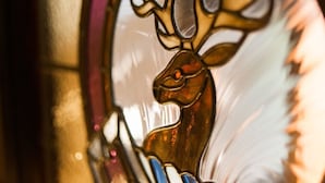 A close-up of a stained glass window featuring a deer. - Alban & Abbey House (Inverness)