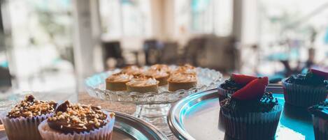 A variety of desserts on a glass serving tray in a well-lit room with a modern interior.
