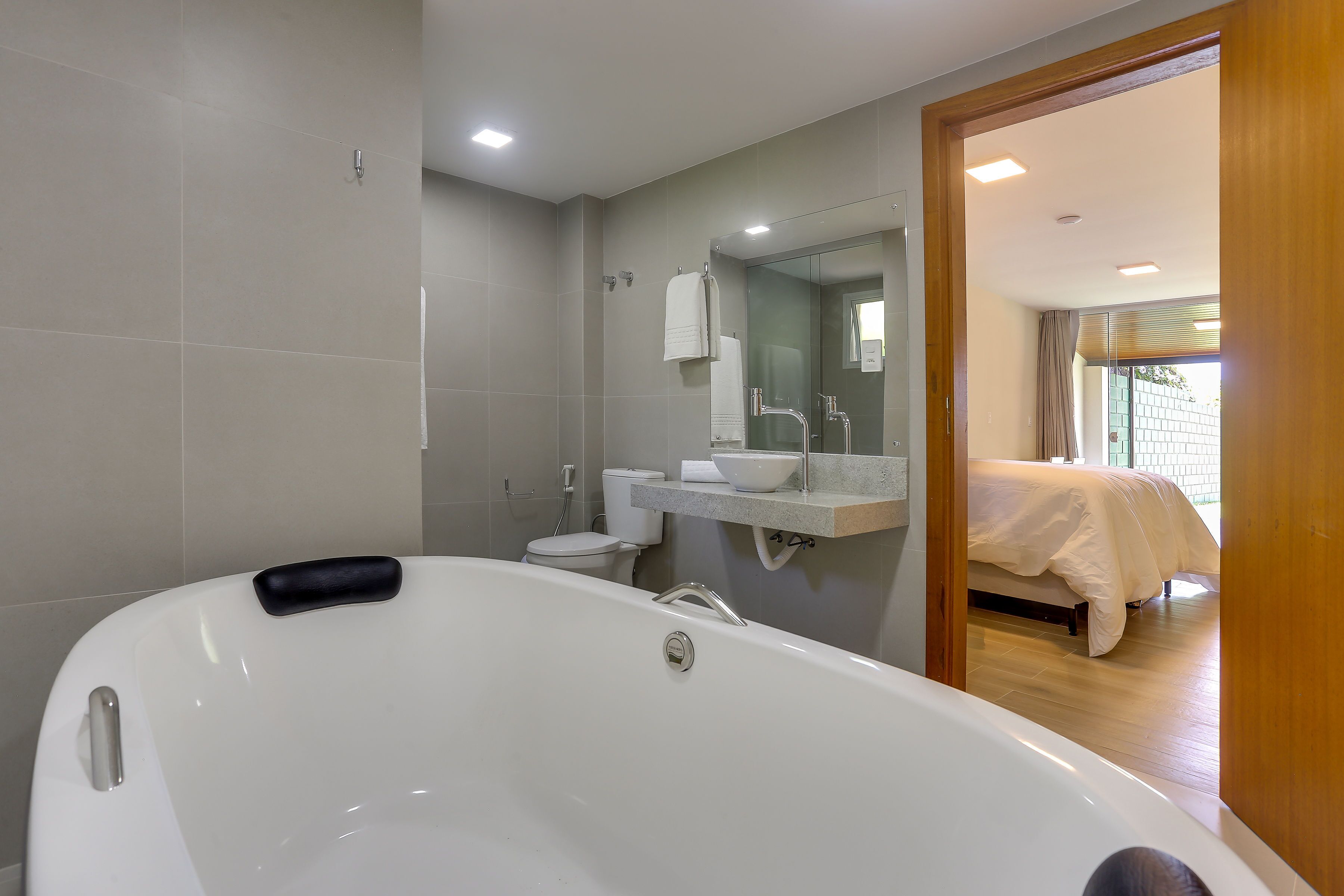 A modern bathroom with a large bathtub, a toilet, and a sink.