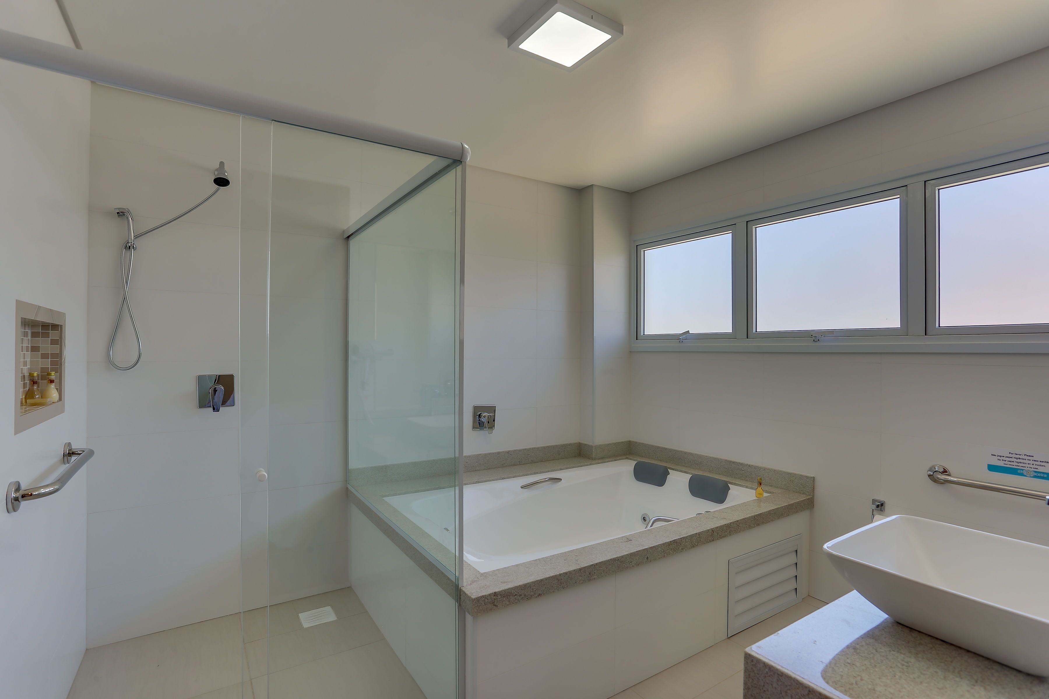 A modern bathroom with a glass-enclosed shower, a freestanding bathtub, and a sink with a vanity.