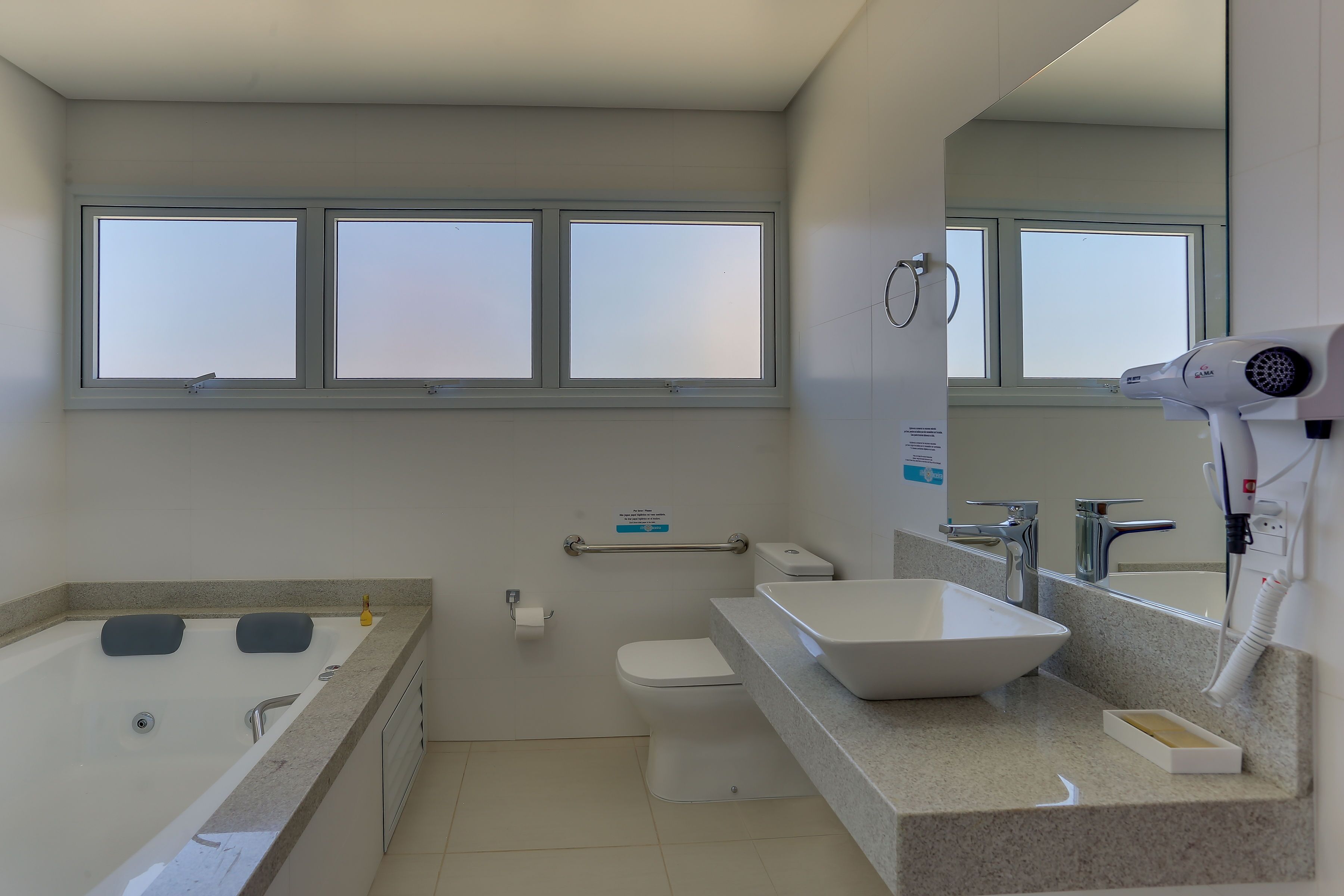 A modern bathroom with a bathtub, toilet, and sink.