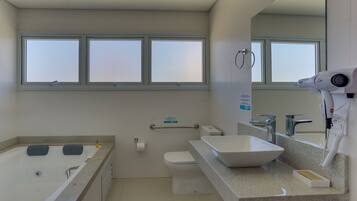 A modern bathroom with a bathtub, toilet, and sink.
