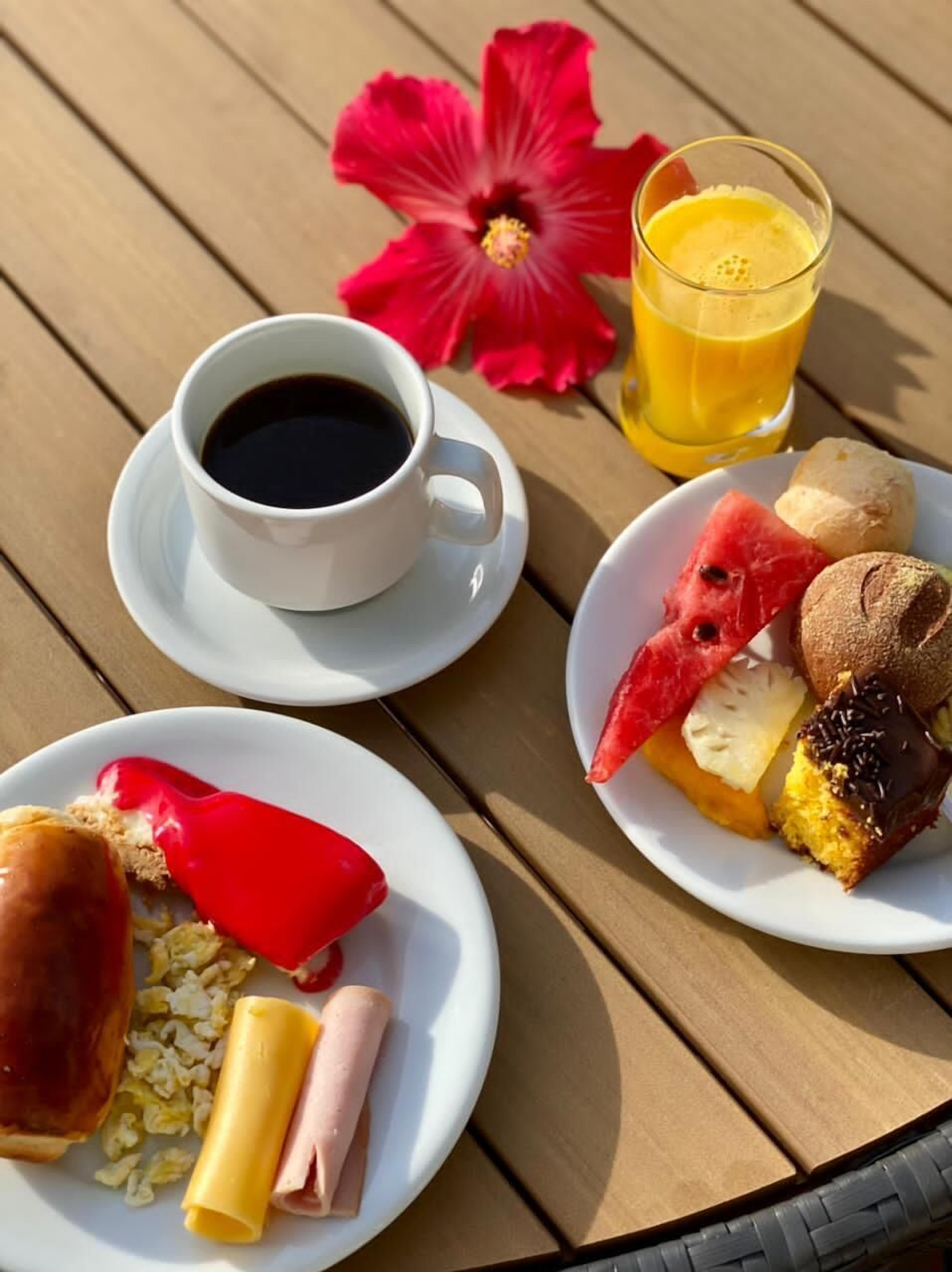 A table with breakfast items including coffee, juice, and various pastries.