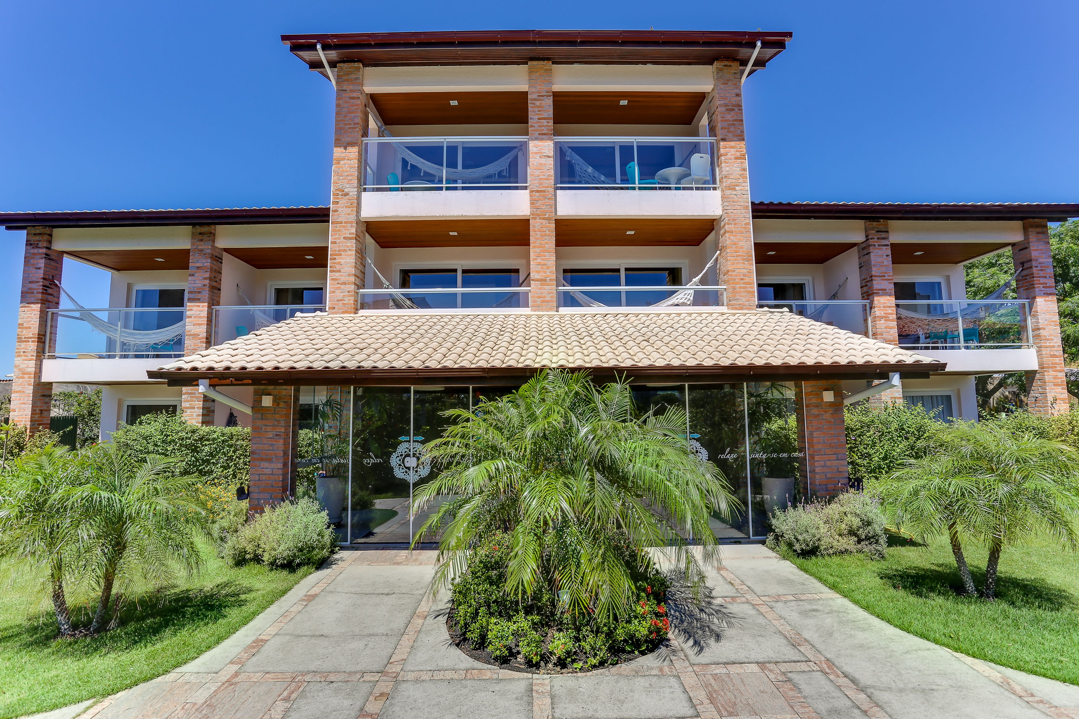 A multi-story building with a brick facade, large windows, and a covered entrance area.