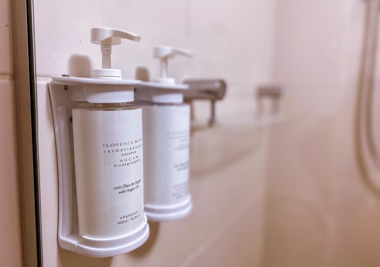 A bathroom with white dispensers for toiletries.