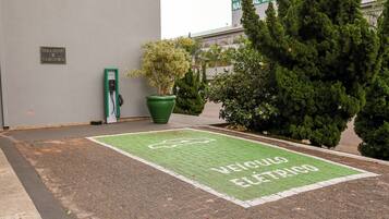 Un área de estacionamiento con una estación de carga para vehículos eléctricos verdes.