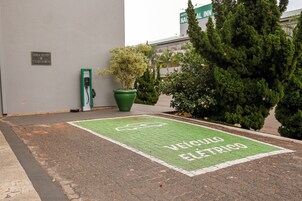 Un área de estacionamiento con una estación de carga para vehículos eléctricos verdes.