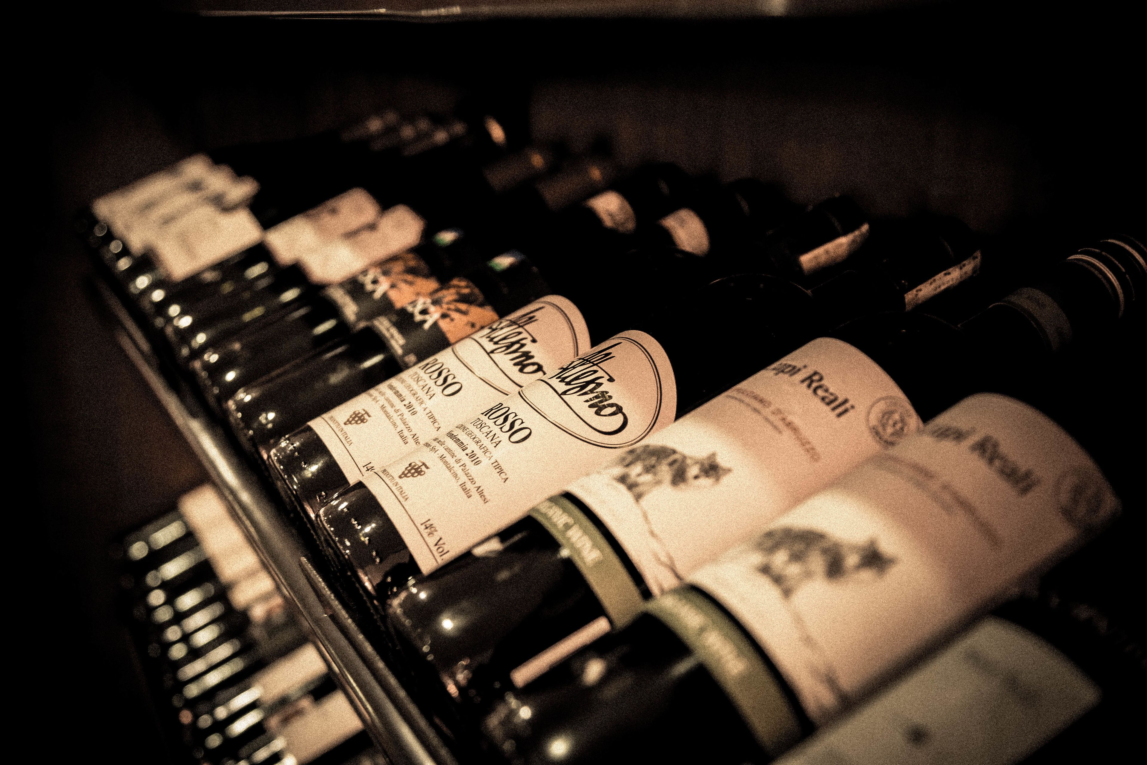 Varias botellas de vino sobre una estantería.
