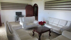 A living room with a sofa set, a coffee table, and a television.