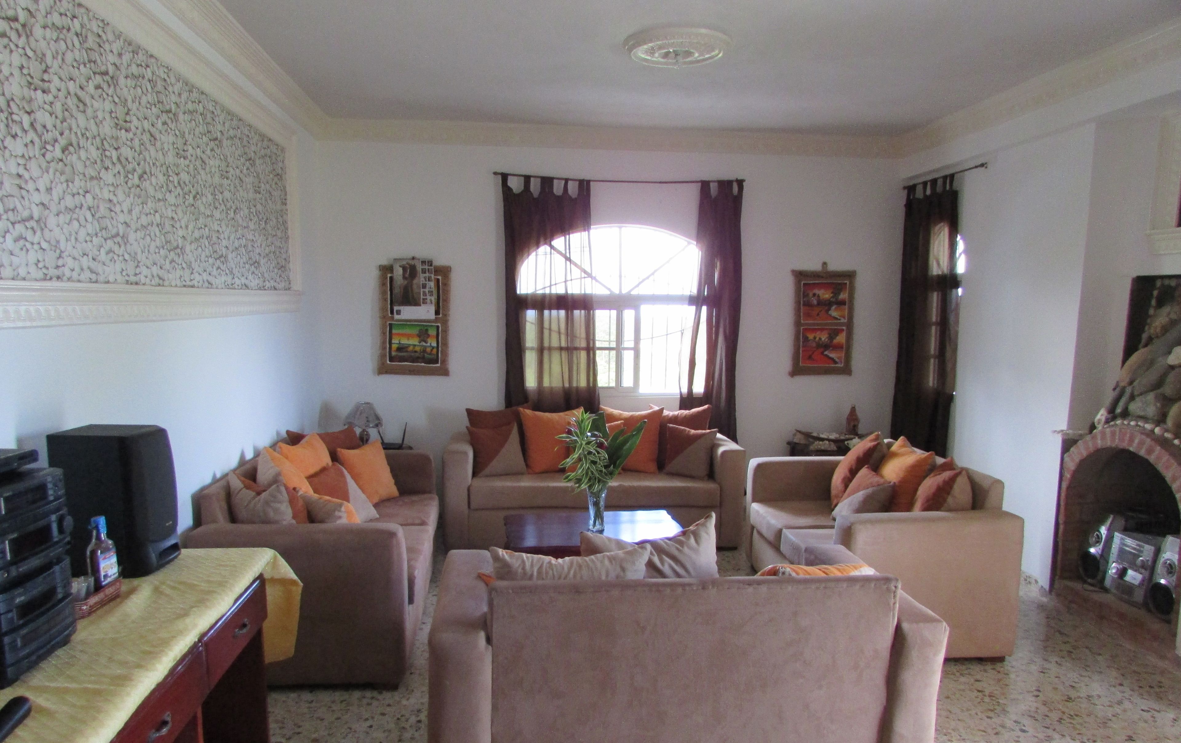 A living room with a fireplace, two sofas, a coffee table, and a television.