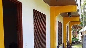 Un espace extérieur abrité, doté de bancs et d’un sol carrelé.