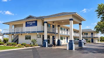 A two-story Travelers Inn with a balcony, a covered walkway, and a parking area.