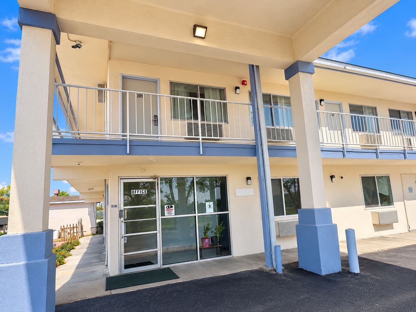 A two-story motel with a ground-level office and a balcony on the upper floor.