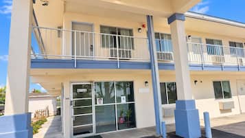 A two-story motel with a ground-level office and a balcony on the upper floor.