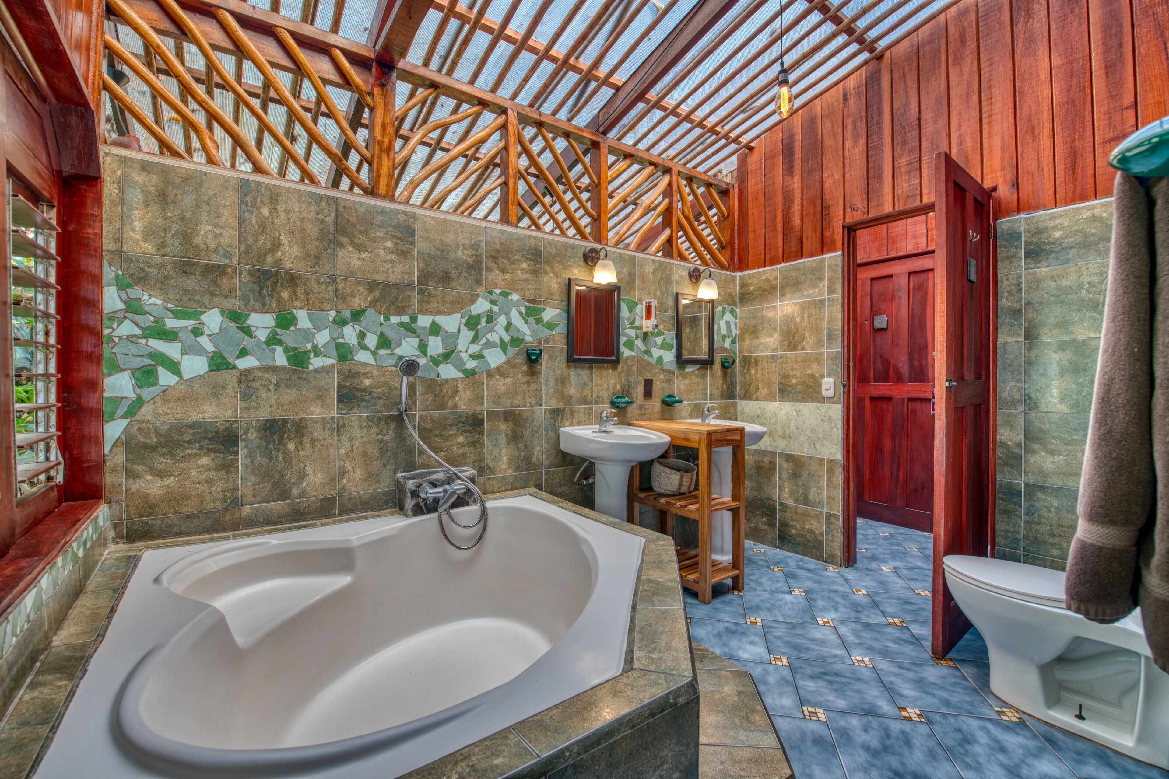 A bathroom with a large bathtub, a sink, and a toilet.