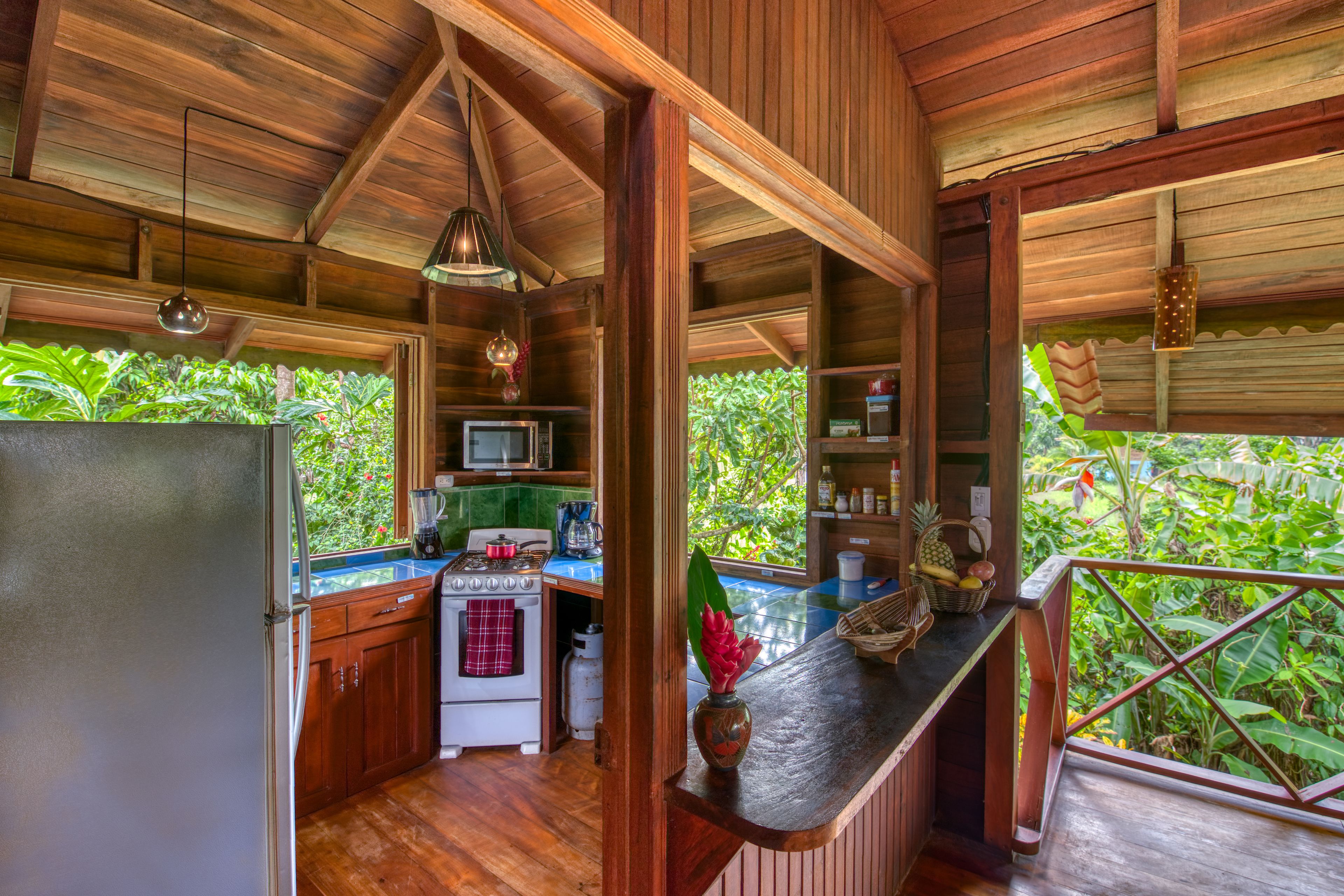 A wooden kitchen with a view of lush greenery.