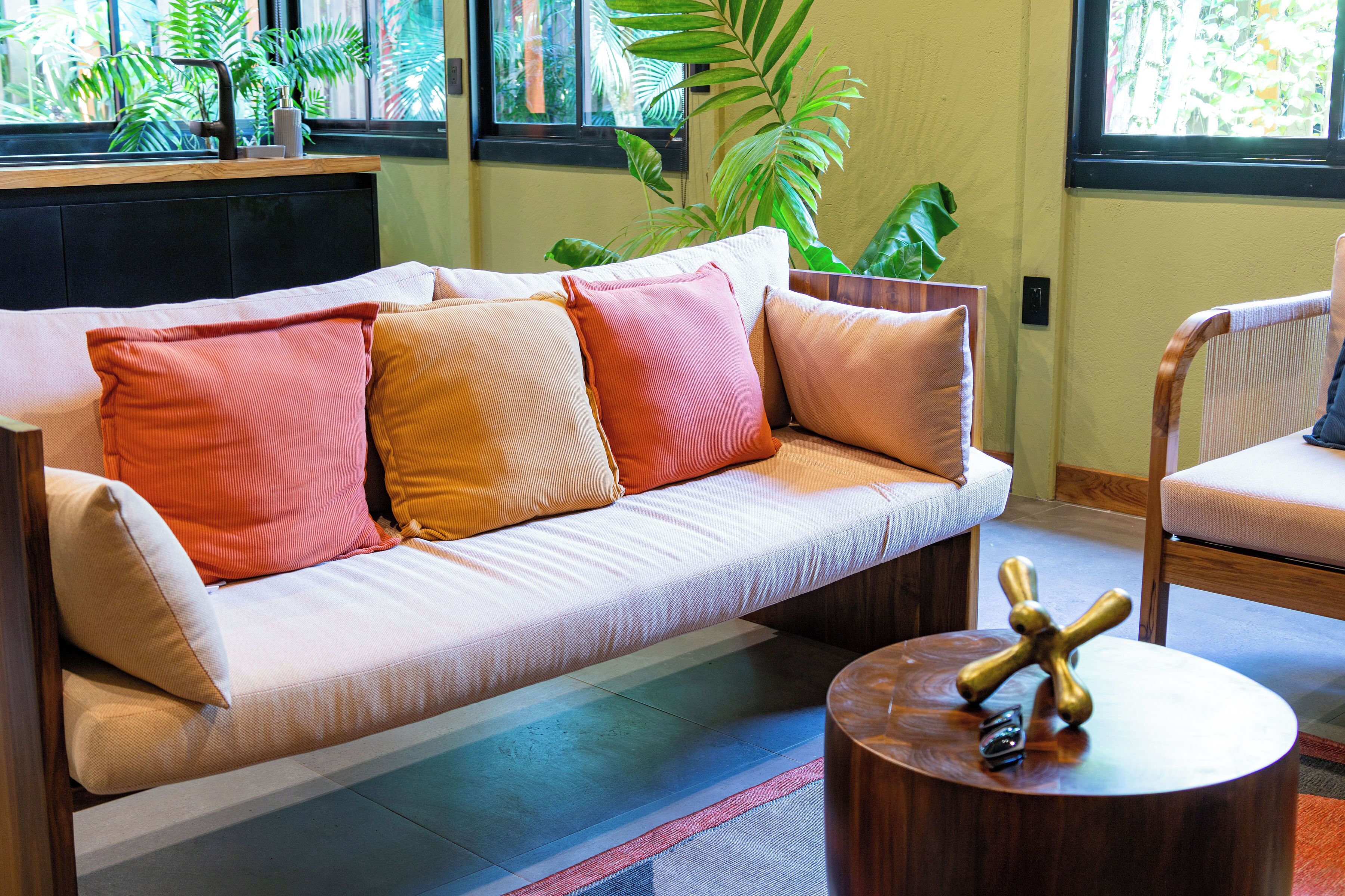 Una sala de estar moderna con un sofá, una mesa de centro de madera y un sillón.