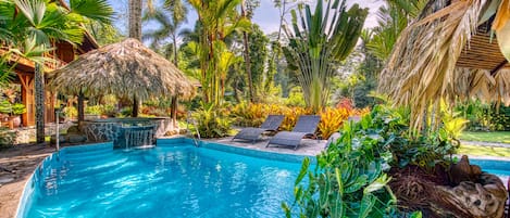 Una piscina al aire libre, sillones reclinables de piscina