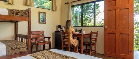 A room with a bunk bed, a desk with a computer, a chair, and a window with curtains.