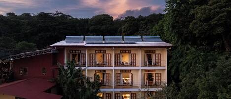 A multi-story building with balconies, solar panels, and a red roof.