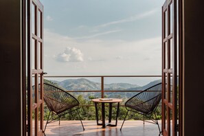 An open balcony with a table and two chairs, overlooking a mountainous landscape. - Valle Escondido Nature Reserve Hotel & Farm (Monteverde)