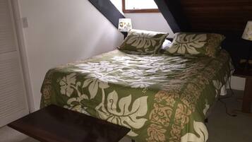A bedroom with a bed, a bench, a window, and a nightstand.