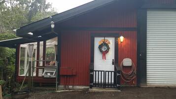 A red building with a white door, a black gate, and a wreath on the door.